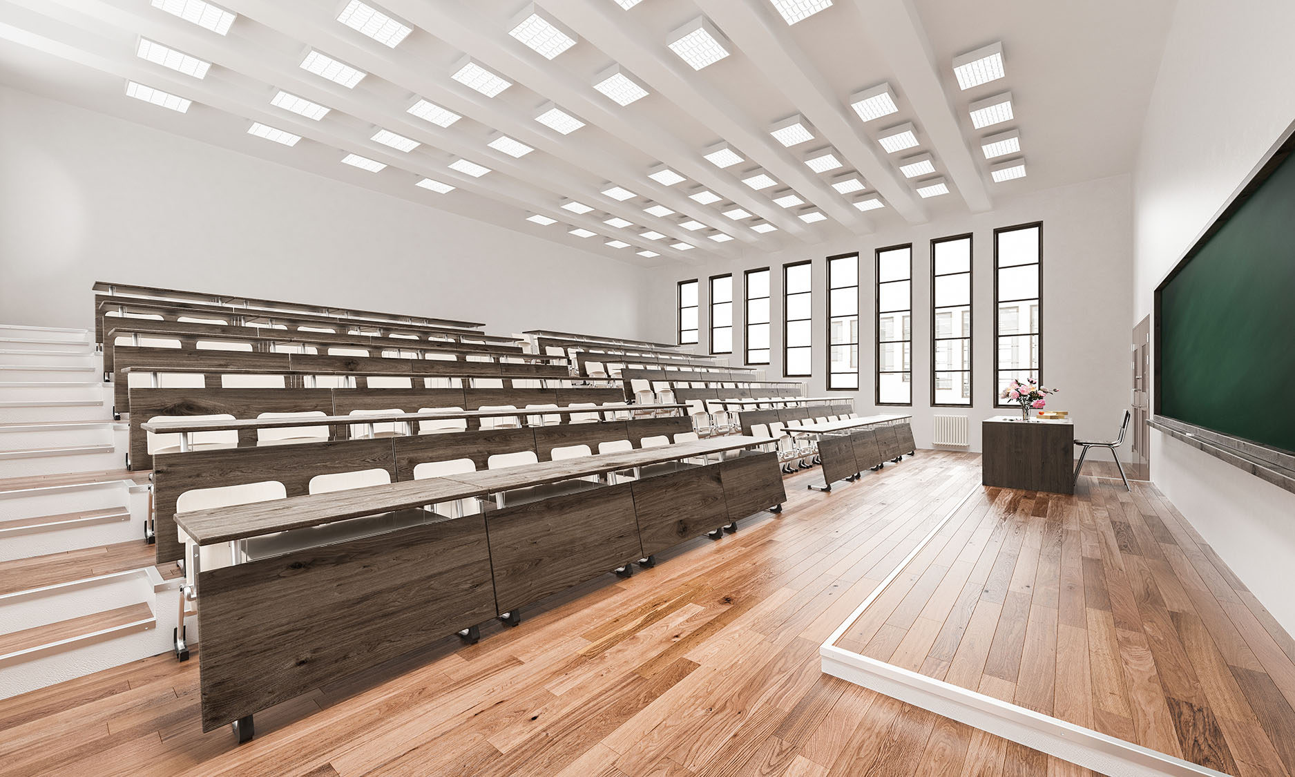 Moderner Hörsaal mit ansteigenden Holzbänken, grüner Kreidetafel und großen Fenstern.